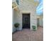 Inviting front entrance with stone accents, brick pathway, and potted plants at 840 Jasmine Creek Rd, Kissimmee, FL 34759