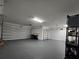 Large, clean garage featuring epoxy flooring and ample storage space with two garage doors at 840 Jasmine Creek Rd, Kissimmee, FL 34759