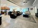 Open-concept living room with tile floors, ceiling fan, and a view of the kitchen and sliding glass doors to the patio at 840 Jasmine Creek Rd, Kissimmee, FL 34759