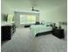 Spacious main bedroom with large window, ceiling fan, neutral carpet, and complemented by dark wood furniture at 840 Jasmine Creek Rd, Kissimmee, FL 34759