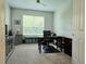 Home office featuring a desk, comfortable chair, media cabinet, and plenty of natural light through a large window at 840 Jasmine Creek Rd, Kissimmee, FL 34759