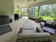 A large screened in patio area with seating, fan, lighting, and view to the landscape at 840 Jasmine Creek Rd, Kissimmee, FL 34759