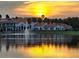 Stunning sunset view over the lake, showcasing the community clubhouse and its beautiful architecture at 840 Jasmine Creek Rd, Kissimmee, FL 34759