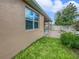 A cozy patio and outdoor fireplace extends from this home with grass, plants, and partial fence for outdoor relaxation at 3125 Winesap Way, Winter Garden, FL 34787