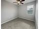 Cozy bedroom with neutral carpet, ceiling fan, and a window with blinds for privacy at 3125 Winesap Way, Winter Garden, FL 34787
