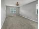 Neutral bedroom with plush carpeting, two windows with blinds, and ample natural light at 3125 Winesap Way, Winter Garden, FL 34787