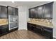 Modern kitchen boasts stainless steel appliances, granite countertops, and stylish tiled backsplash at 3125 Winesap Way, Winter Garden, FL 34787
