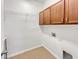 Bright laundry room with overhead cabinets, wire shelving, and washer/dryer hookups at 3125 Winesap Way, Winter Garden, FL 34787