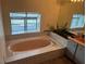 Bathroom with an oval tub, tiled walls, and a large vanity at 9524 Bay Vista Estates Blvd, Orlando, FL 32836