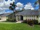 Green house with gray roof, landscaping, and palm trees at 9524 Bay Vista Estates Blvd, Orlando, FL 32836