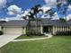 Two-story house with a gray roof, green exterior, and a palm tree at 9524 Bay Vista Estates Blvd, Orlando, FL 32836