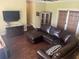 Spacious living room featuring a large leather sectional sofa and dark hardwood floors at 9524 Bay Vista Estates Blvd, Orlando, FL 32836