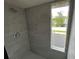 Shower with gray tile and a window at 9524 Bay Vista Estates Blvd, Orlando, FL 32836