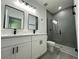 Modern bathroom features a double sink vanity with white cabinets and black hardware, plus a glass-enclosed shower at 14954 Sw 38Th Cir, Ocala, FL 34473