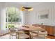 Elegant dining room with large window, oval wood table, and chandelier at 222 Acadia Ter, Celebration, FL 34747