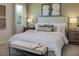 Comfortable bedroom with a large bed, neutral colors, decorative pillows, artwork and a window offering natural light at 168 Duckweed Ave, Fruitland Park, FL 34731
