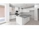 Modern kitchen with white cabinets, center island, stainless steel appliances, and gray countertops at 1231 Teal Creek Dr, St Cloud, FL 34771