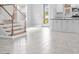 Open-concept living space featuring tile flooring, staircase, and a view into a bright, modern kitchen at 1231 Teal Creek Dr, St Cloud, FL 34771