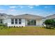 Rear view of a home with a well-manicured lawn and a covered patio, perfect for outdoor living at 5267 Stone Ridge Pl, St Cloud, FL 34771