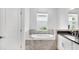 Bathroom showcasing a standalone tub with tile surround, plus a double sink vanity at 5267 Stone Ridge Pl, St Cloud, FL 34771