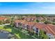 Community aerial view highlighting the terracotta roofs, green spaces, and waterfront views at 5536 Metrowest Blvd # 8-304, Orlando, FL 32811