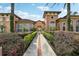 Inviting clubhouse with arched entrance, lush landscaping, and Mediterranean-style architecture at 5536 Metrowest Blvd # 8-304, Orlando, FL 32811