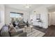 Sunlit living room with dark floors, stylish furnishings and a view to the balcony at 5536 Metrowest Blvd # 8-304, Orlando, FL 32811