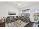 Bright living room features modern decor, large window, and ceiling fan at 5536 Metrowest Blvd # 8-304, Orlando, FL 32811