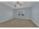 Well-lit bedroom featuring carpeted floors and a large window at 10747 Belfry Cir, Orlando, FL 32832