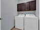 Laundry room with washer, dryer, and upper cabinets at 10747 Belfry Cir, Orlando, FL 32832