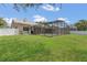 Spacious backyard featuring a screened-in pool area and well-maintained lawn, ideal for outdoor activities at 1121 Trotwood Blvd, Winter Springs, FL 32708
