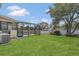 Lush backyard with a screened pool enclosure, providing a peaceful retreat with ample green space at 1121 Trotwood Blvd, Winter Springs, FL 32708