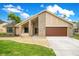 Inviting single-story home with a brick and stucco facade, featuring a two-car garage and well-maintained landscaping at 1121 Trotwood Blvd, Winter Springs, FL 32708