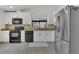 Bright kitchen features white cabinets, granite counters, stainless steel refrigerator, and modern appliances at 1121 Trotwood Blvd, Winter Springs, FL 32708