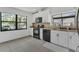 Well-lit kitchen featuring white cabinets, black appliances, granite countertops, and tile flooring at 1121 Trotwood Blvd, Winter Springs, FL 32708