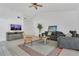 Comfortable living room showcasing tile floors, a ceiling fan, and a stylish gray sofa for relaxing and entertaining at 1121 Trotwood Blvd, Winter Springs, FL 32708