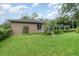 Green backyard with lush lawn and brick house with large windows at 5100 Linwood Cir, Sanford, FL 32771