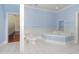 Bathroom featuring a tub, toilet, and blue wainscoting, including a view into a bedroom at 5100 Linwood Cir, Sanford, FL 32771