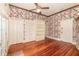 Bedroom featuring hardwood floors, built-in shelving, and floral wallpaper at 5100 Linwood Cir, Sanford, FL 32771