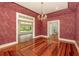 Formal dining room boasts decorative wallpaper, chandelier, hardwood floors, and views to the outside at 5100 Linwood Cir, Sanford, FL 32771