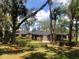 Charming single-story brick home with a well-manicured lawn and mature trees creating a serene setting at 5100 Linwood Cir, Sanford, FL 32771