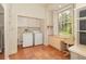 Bright laundry room offers modern washer and dryer, built-in desk, and a large window at 5100 Linwood Cir, Sanford, FL 32771