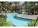Scenic lazy river featuring a bridge, lush landscaping, and inviting water for a relaxing experience at 1585 Mulligan Blvd, Davenport, FL 33896