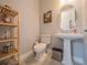 Stylish powder room with pedestal sink and wood shelving at 2310 Hamilton Ridge Rd, Clermont, FL 34715