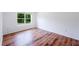 Cozy bedroom with natural light from the window and warm wood-look flooring at 2950 Gibraltar Blvd, New Smyrna Beach, FL 32168
