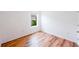 Minimal bedroom with hardwood floors and a bright view from the single window at 2950 Gibraltar Blvd, New Smyrna Beach, FL 32168