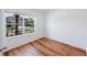 Bright bedroom featuring new wood flooring and a large window showcasing the exterior landscape at 2950 Gibraltar Blvd, New Smyrna Beach, FL 32168