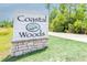 Coastal Woods community entrance sign surrounded by lush landscaping, inviting residents and visitors at 2950 Gibraltar Blvd, New Smyrna Beach, FL 32168