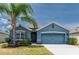 Charming one-story home with blue exterior, palm tree, two-car garage, and well-manicured lawn at 2950 Gibraltar Blvd, New Smyrna Beach, FL 32168