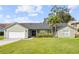 Charming single-Gathering home featuring a well-manicured lawn and attached two-car garage at 301 Richard Pl, Orlando, FL 32806